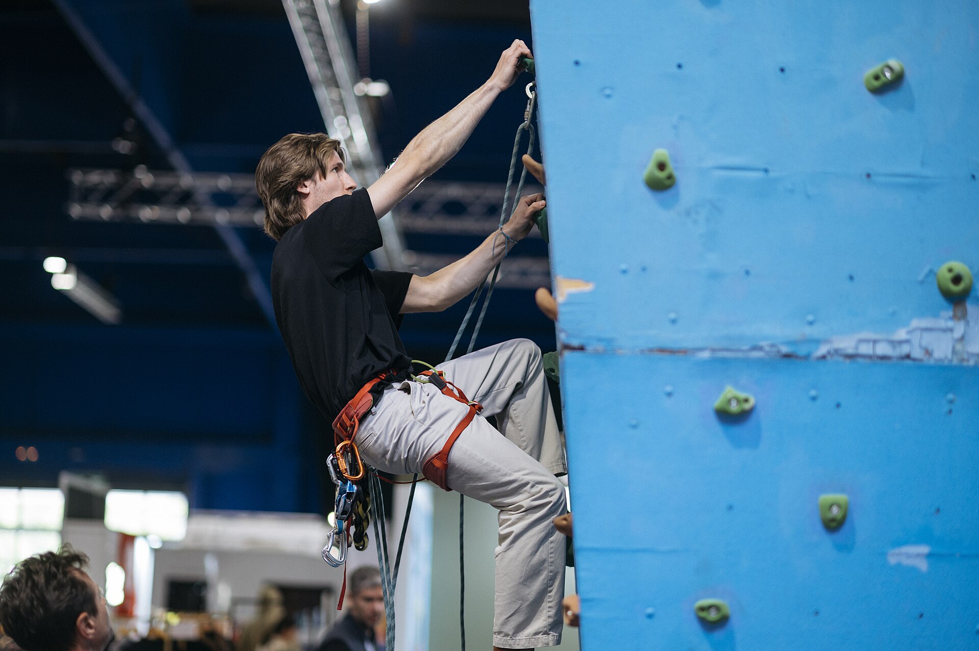 Тренер на стене демонстрирует движение на нависании